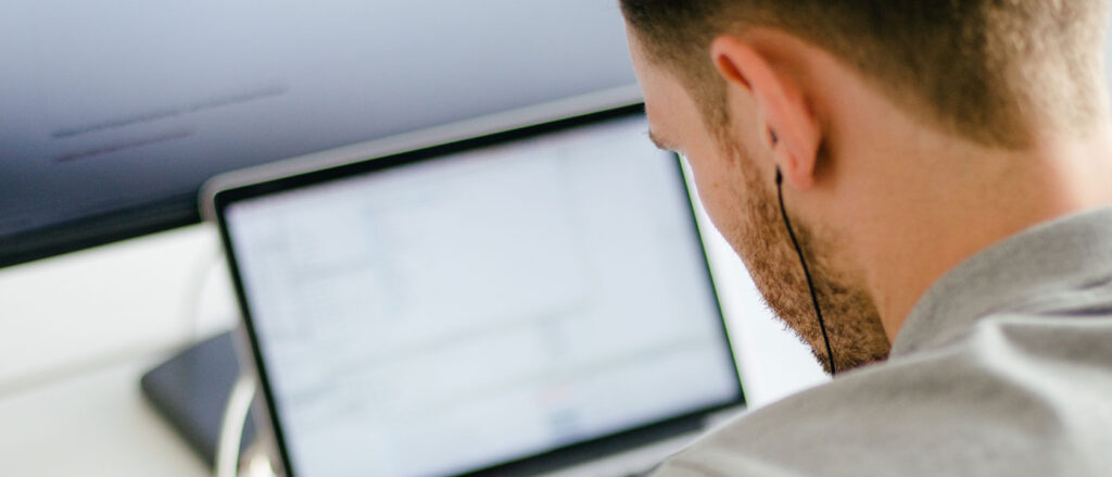 Mężczyzna patrzy na monitor. Ma problemy ze stroną, potrzebuje opieki wordpress
